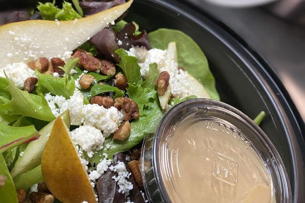 Individually packaged salad with mixed greens, pears, cheese and nuts