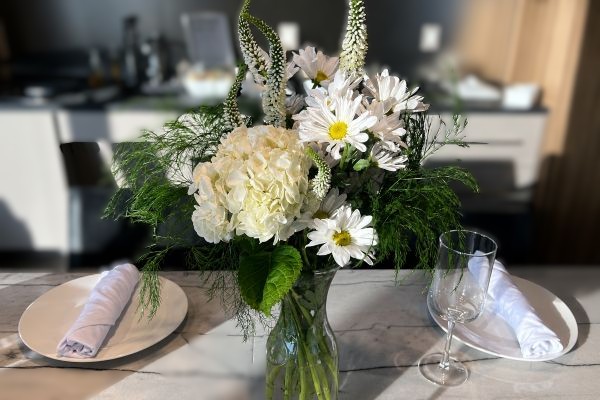 White floral centerpiece with hydrangeas, daisies and fresh greenery