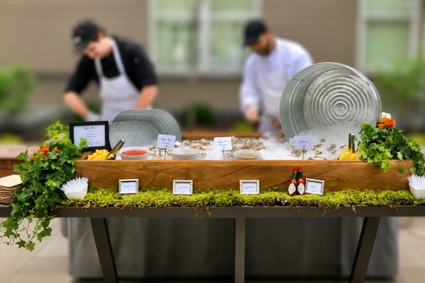 Outdoor oyster bar display with fresh oysters, sauces and garnishes