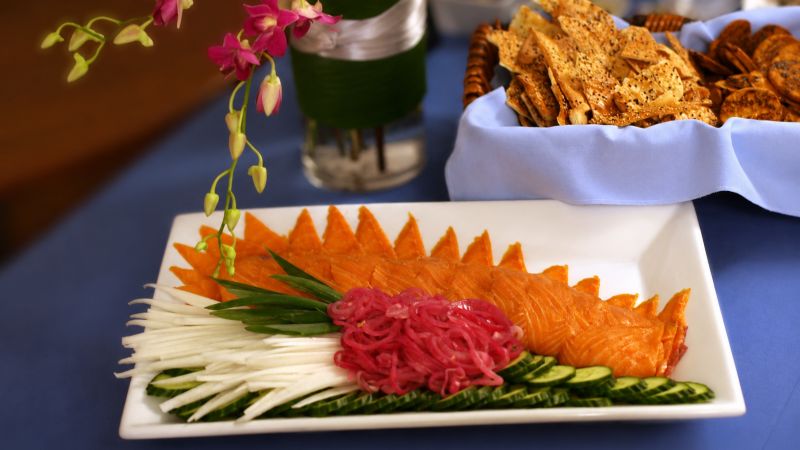 Smoked salmon platter with fresh garnishes, artisan crackers, and orchids