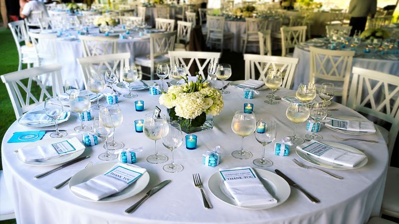 Elegant wedding reception table setting with white florals and turquoise accents