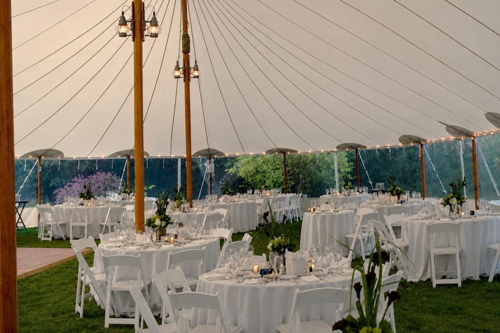 Elegant sailcloth wedding tent with reception tables and floral centerpieces